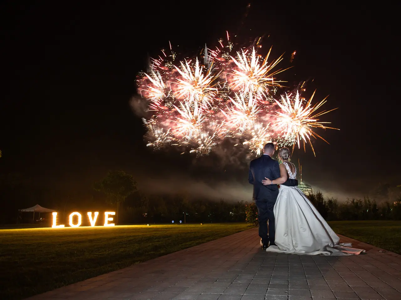 Un feu d'artifice sur mesure pour un mariage, illuminant un couple qui profite d'un spectacle romantique.